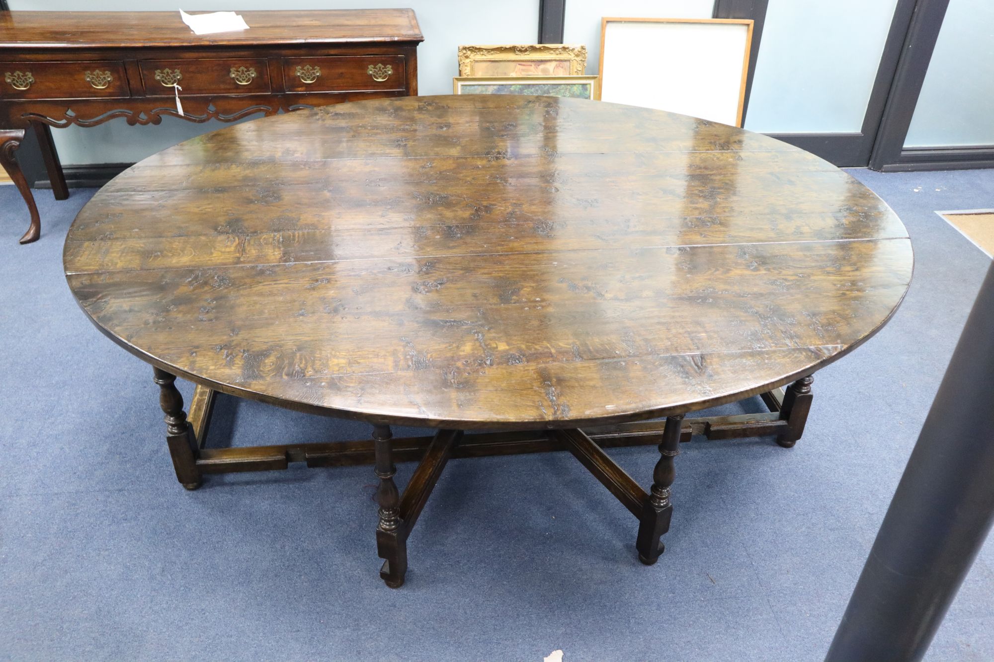 A late 17th century style oak oval topped, double gate leg dining table, width 214cm depth 180cm (extended) height 75cm